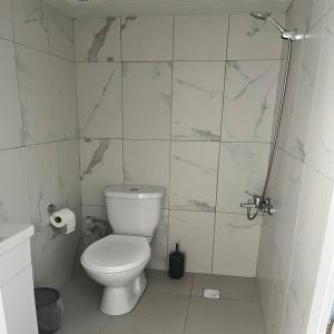 a white bathroom with a toilet and a shower at GRAND WHİTE SUİT OTEL in Sivas