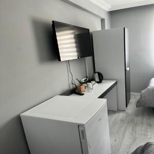 a white refrigerator with a television on top of it at GRAND WHİTE SUİT OTEL in Sivas