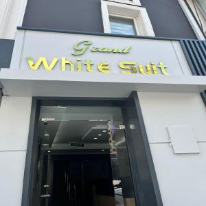 einen vorderen Eingang zu einem weißen Gebäude mit einem Schild darauf in der Unterkunft GRAND WHİTE SUİT OTEL in Sivas