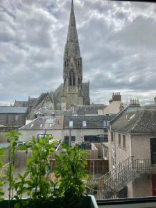 a church with a tall steeple in a city at Sunny apartment by the river in Kelso