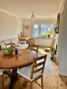 a living room with a wooden table and chairs at Sunny apartment by the river in Kelso