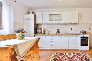 a kitchen with white cabinets and a table at Kwatery u Jacka in Groń