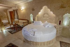 a bedroom with a large white bed in a room at Kemerhan Cave Suites in Ürgüp