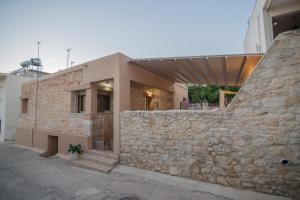 a stone building with a stone wall and stairs at Silva Luxury House in Mires (South Crete) in Moírai