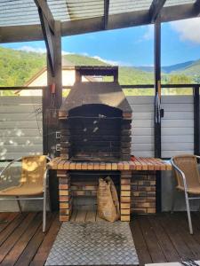 a patio with an outdoor fireplace on a deck at Du bon temps in Bôo-Silhen