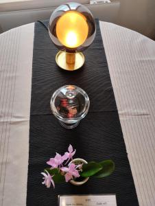 a table with a candle and flowers on it at Manoir de la Guignardiere : Thé ou café ? in Chavagne