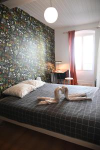 - une chambre avec deux pélicans posés sur un lit dans l'établissement La Gaieté - Meilleurhote-Brioude, à Brioude