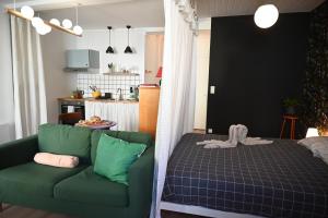- un salon avec un canapé vert et un lit dans l'établissement La Gaieté - Meilleurhote-Brioude, à Brioude