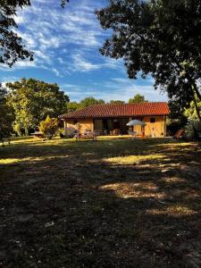 ein Haus mit rotem Dach auf einem Feld in der Unterkunft Maison à l’orée du bois in Soustons