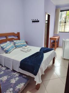 a bedroom with a large bed with blue sheets at Pousada Hotel Lumiar in Lumiar