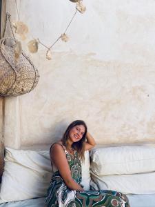 a woman sitting on top of a bed at Baben Home in Siwa