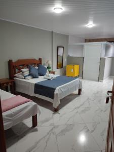 una camera con 2 letti in una stanza con pavimenti in marmo di Pousada Hotel Lumiar a Lumiar