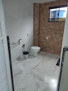 Baño blanco con aseo y lavamanos en Pousada Hotel Lumiar, en Lumiar