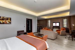 a hotel room with a bed and a living room at Best Western Plus The Athena Hotel Kampala in Kampala