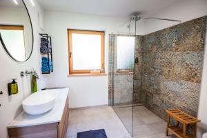 bagno con lavandino e doccia di Ferienhäuser Koralpe unicorn village a Wolfsberg
