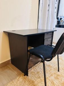 a black desk with a chair in a room at The Ivy Suite- one bedroom 3 mins away from Ruiru Rainbow Resort in Ruiru