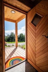 una puerta abierta a un patio con una alfombra de arco iris en Ferienhäuser Koralpe unicorn village en Wolfsberg