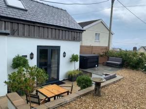 um quintal com uma mesa de madeira e um banco em The Side, Gower - Cosy, Coastal, Sea Views & Hot Tub em Horton