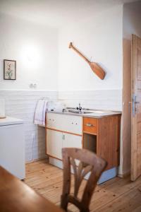 uma cozinha com um lavatório e uma cadeira de madeira em Ferienwohnung Alter Brotladen em Melk