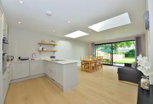 eine Küche mit weißen Schränken und ein Wohnzimmer in der Unterkunft Sky View in Winchester