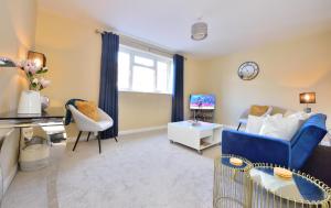 a living room with a blue couch and a tv at Sky View in Winchester