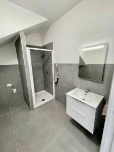 La salle de bains blanche est pourvue d'un lavabo et d'une douche. dans l'établissement Appartamento Marco Simone, à Marco Simone