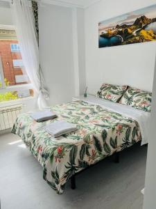 1 dormitorio con 1 cama con manta de flores en Apartamento en Santander, en Santander