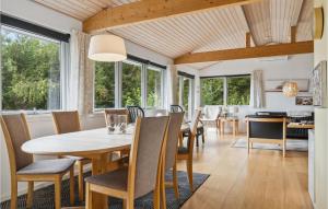 a dining room with a table and chairs and windows at 3 Bedroom Pet Friendly Home In Ebeltoft in Ebeltoft
