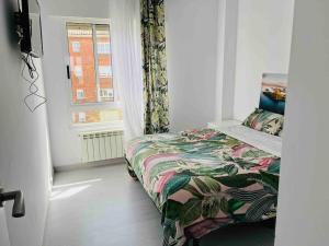 a small bedroom with a bed and a window at Apartamento en Santander in Santander