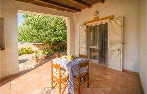 a table and chairs sitting on a patio with a window at Beautiful Home In Marinella Di Selinunte With Kitchenette in Marinella di Selinunte