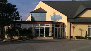 a large white building with glass doors on a street at Penzion Lapáš u Hoffera in Nitra