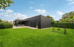 ヒュールスミンネにあるAmazing Home In Juelsminde With 4 Bedrooms And Wifiの目標を掲げた草の庭の黒い家