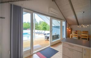 ØrbyにあるNice Home In Knebel With Sauna, Wifi And Outdoor Swimming Poolのプールにつながるガラスの引き戸付きのキッチン