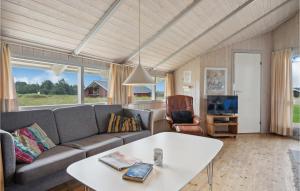 a living room with a couch and a table at 4 Bedroom Stunning Home In Hvide Sande in Havrvig