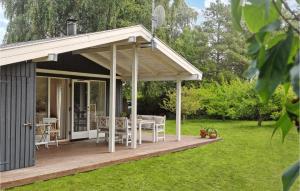 een paviljoen met een tafel en stoelen op een terras bij 3 Bedroom Amazing Home In Bog By in Bogø By