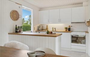 een keuken met witte kasten en een tafel bij 3 Bedroom Amazing Home In Bog By in Bogø By