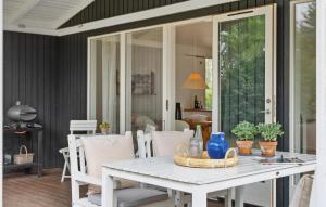 a white table and chairs on a porch at 3 Bedroom Amazing Home In Bog By in Bogø By