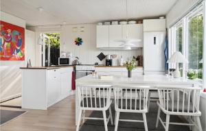 - une cuisine avec des placards blancs, une table et des chaises dans l'établissement 3 Bedroom Beautiful Home In Vordingborg, à Vordingborg