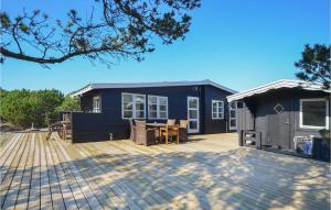 Ce cottage bleu dispose d'une terrasse et d'une maison. dans l'établissement Cozy Home In Anholt With Wifi, à Anholt