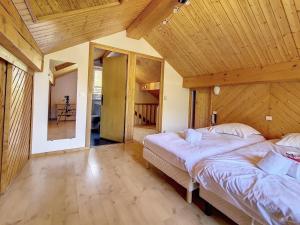 2 Betten in einem Zimmer mit Holzdecke in der Unterkunft Chalet charmant au village avec cheminée, terrasse et parking - FR-1-688-57 in Méribel