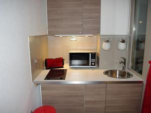 uma pequena cozinha com um micro-ondas e um lavatório em Studio Brides-les-Bains, 1 pièce, 4 personnes - FR-1-512-217 em Brides-les-Bains