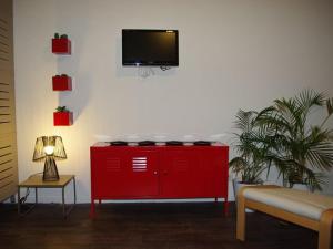 um armário vermelho com uma televisão de ecrã plano na parede em Studio Brides-les-Bains, 1 pièce, 4 personnes - FR-1-512-217 em Brides-les-Bains