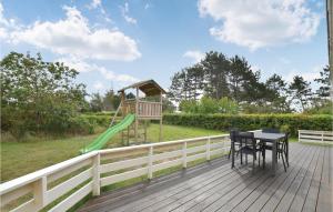 KnebelにあるAwesome Home In Knebel With 3 Bedrooms, Sauna And Wifiのデッキ(プレイグラウンド、テーブル、椅子付)