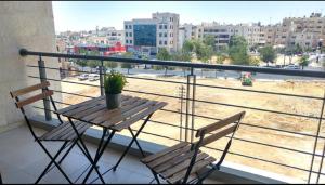 - Balcón con mesa y sillas y vistas a la ciudad en AlMashreq Building, en Amán