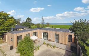 een uitzicht op een houten huis met de oceaan op de achtergrond bij Awesome Home In Tranekr With House Sea View in Tranekær