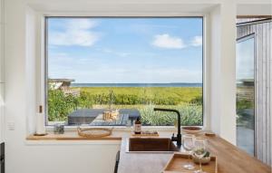 een keuken met een groot raam met uitzicht op de oceaan bij Awesome Home In Tranekr With House Sea View in Tranekær