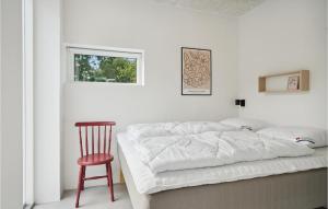 een slaapkamer met een bed, een stoel en een raam bij Awesome Home In Tranekr With House Sea View in Tranekær