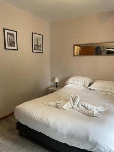 1 dormitorio con 1 cama blanca grande y toallas. en Superbe appartement face au Château - 2 chambres - Netflix/Canal+, en Sedan