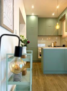 a kitchen with green cabinets and a vase on a glass table at Caruso apartment in Tivat