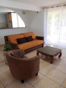 a living room with a couch and a coffee table at Entre mer et montagne in Le Tampon